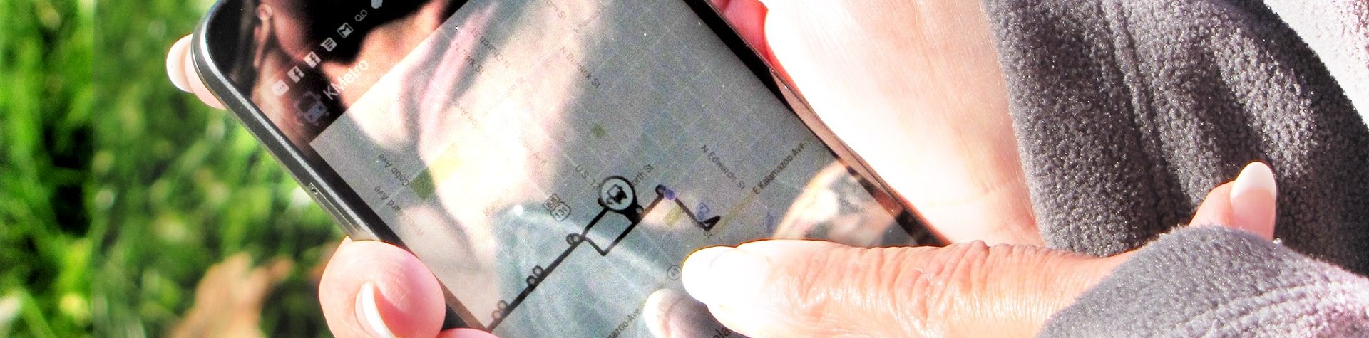 An image of a passenger using the Kalamazoo Metro application on their phone.